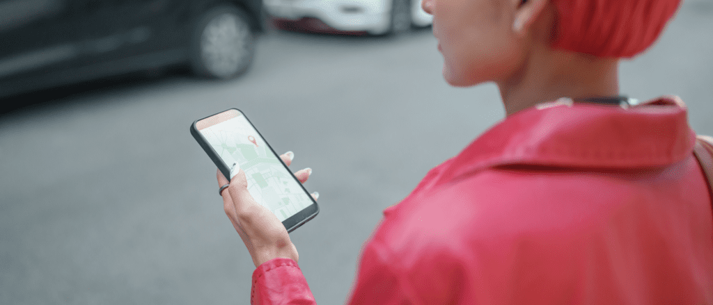 woman in pink jacket using phone for directions