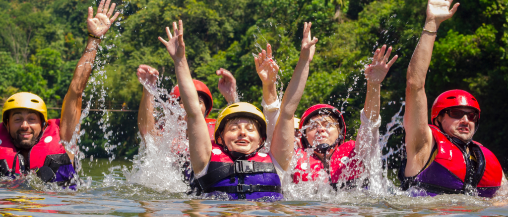 people in a river with their hands up