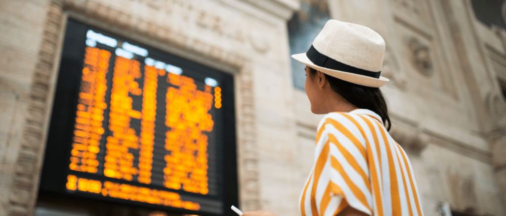 woman looking at a schedule in a train station