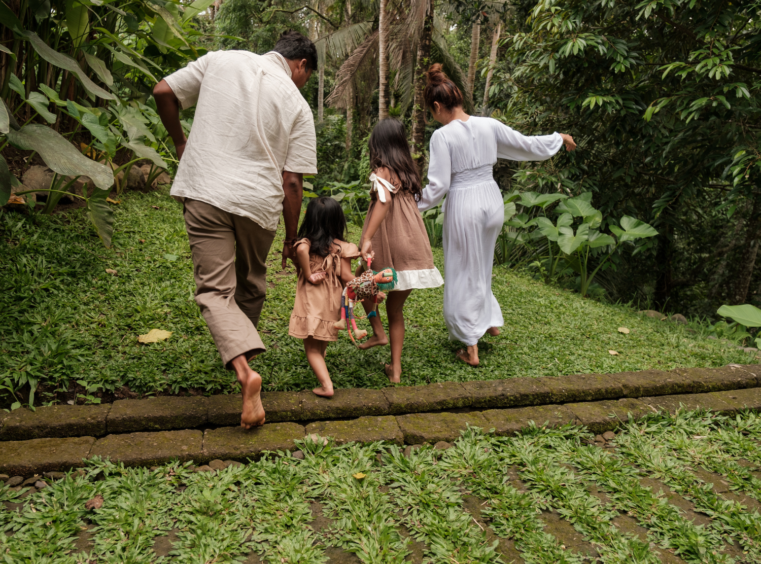 family hopping over a log
