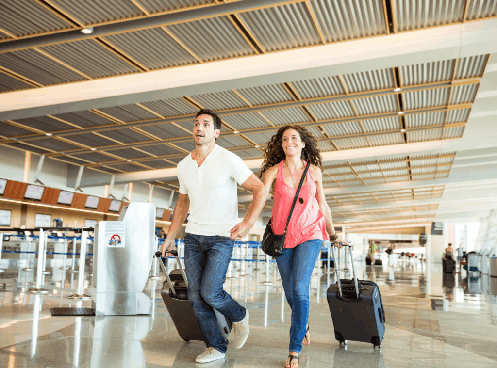Man and woman running in an airport with bags