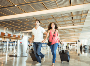 Man and woman running in an airport with bags